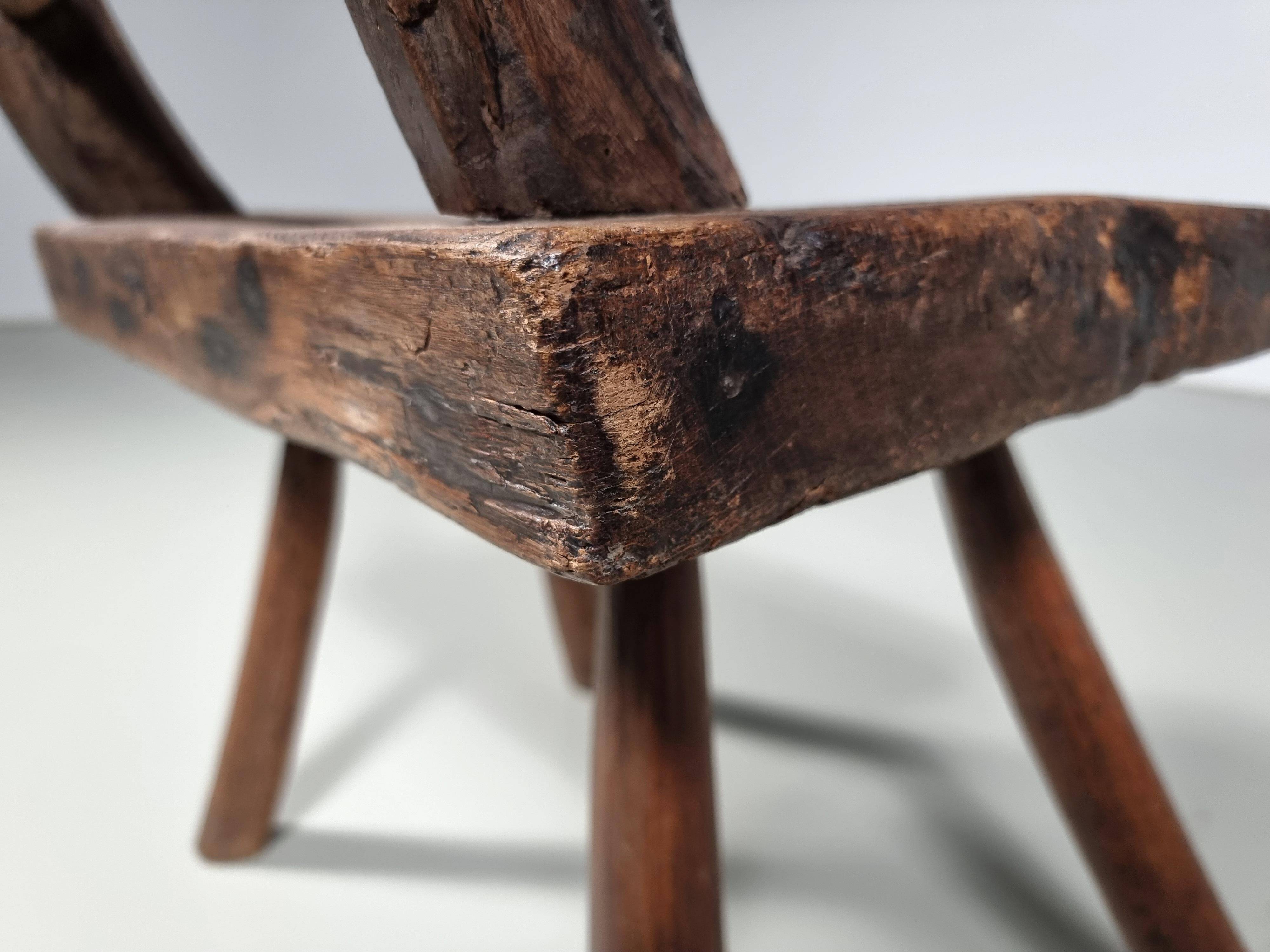 Rustic Wabi-Sabi style accent chair in dark curved hardwood, 1900s.