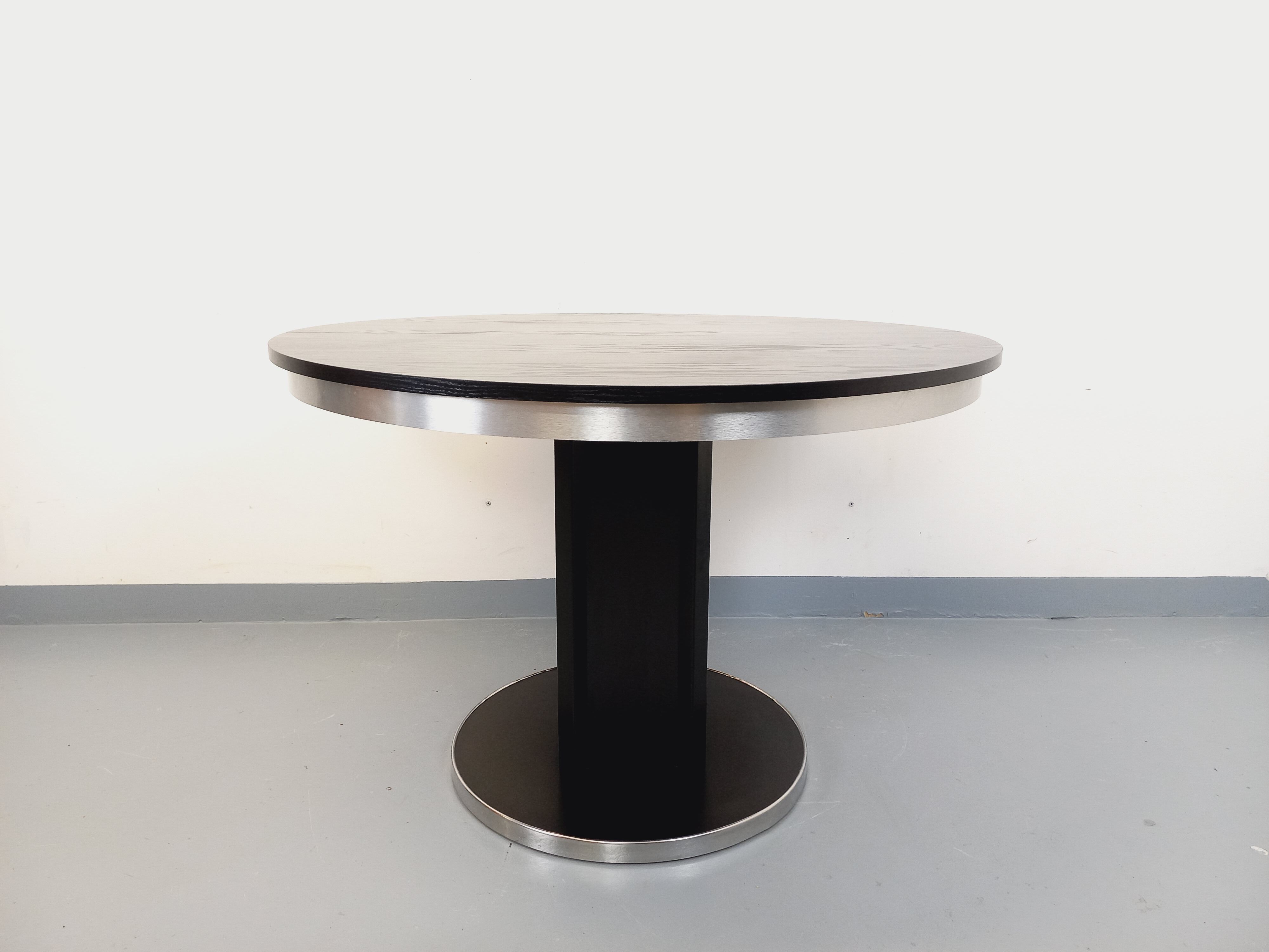 Vintage dining table in melamine with a black wood effect and chrome metal.