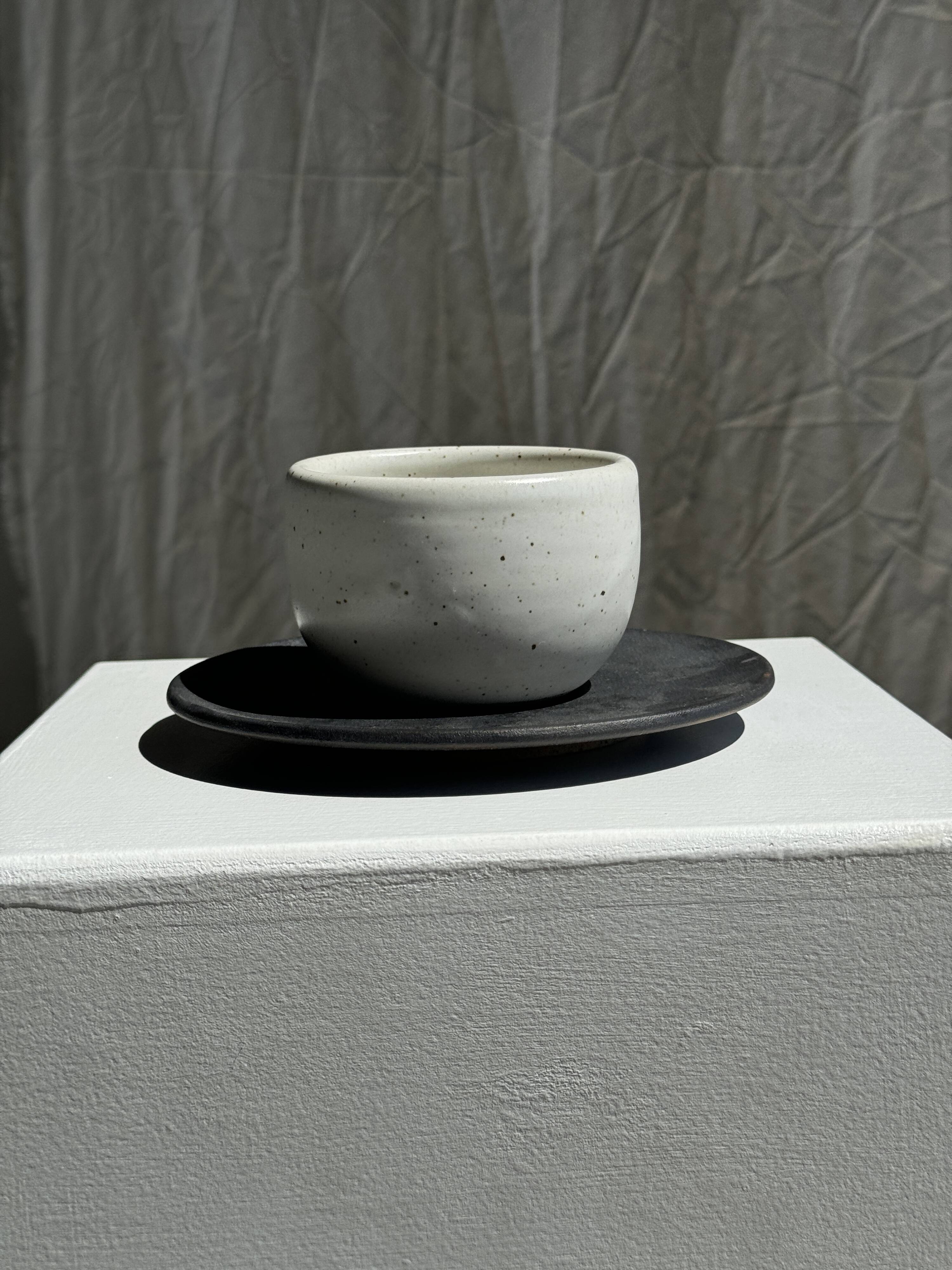 White Indonesian ceramic cup and gray saucer