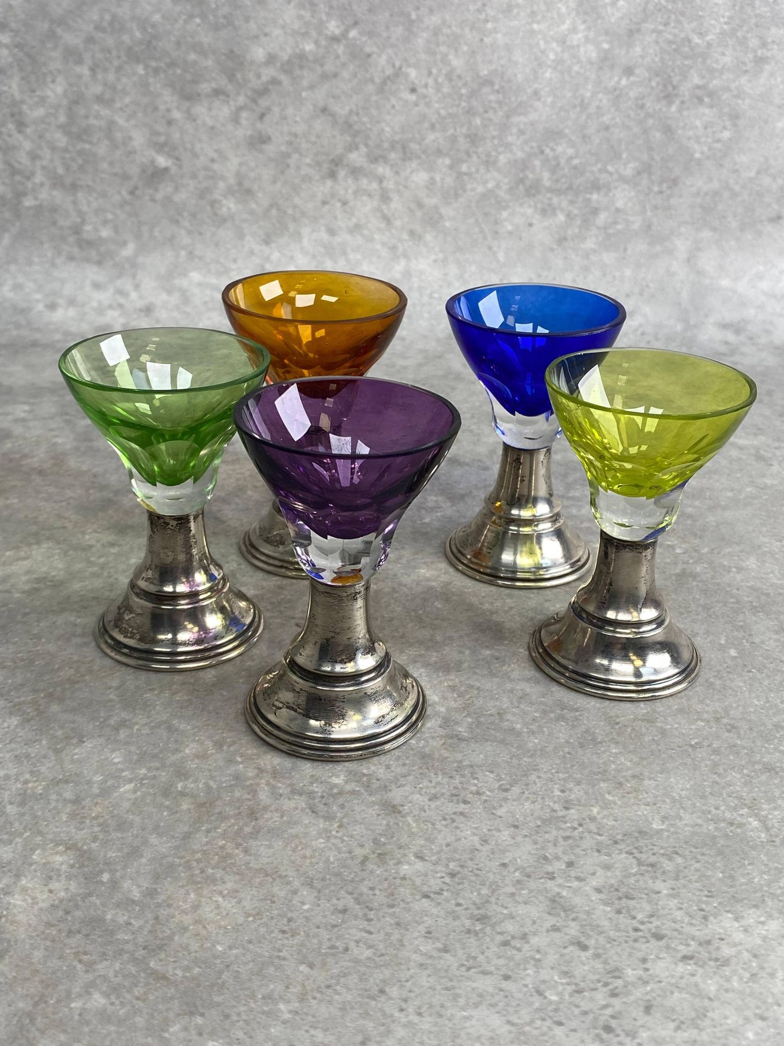Set of 5 coloured stemmed glasses on silver stems.
