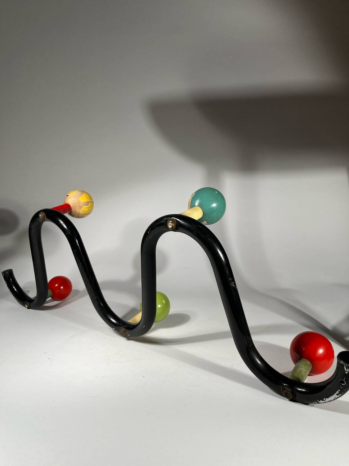 Coat rack in black lacquered metal and colored wooden balls
