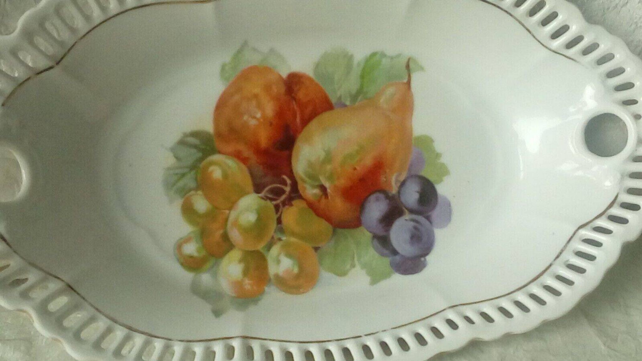 Pierced porcelain basket decorated with fruit still life.