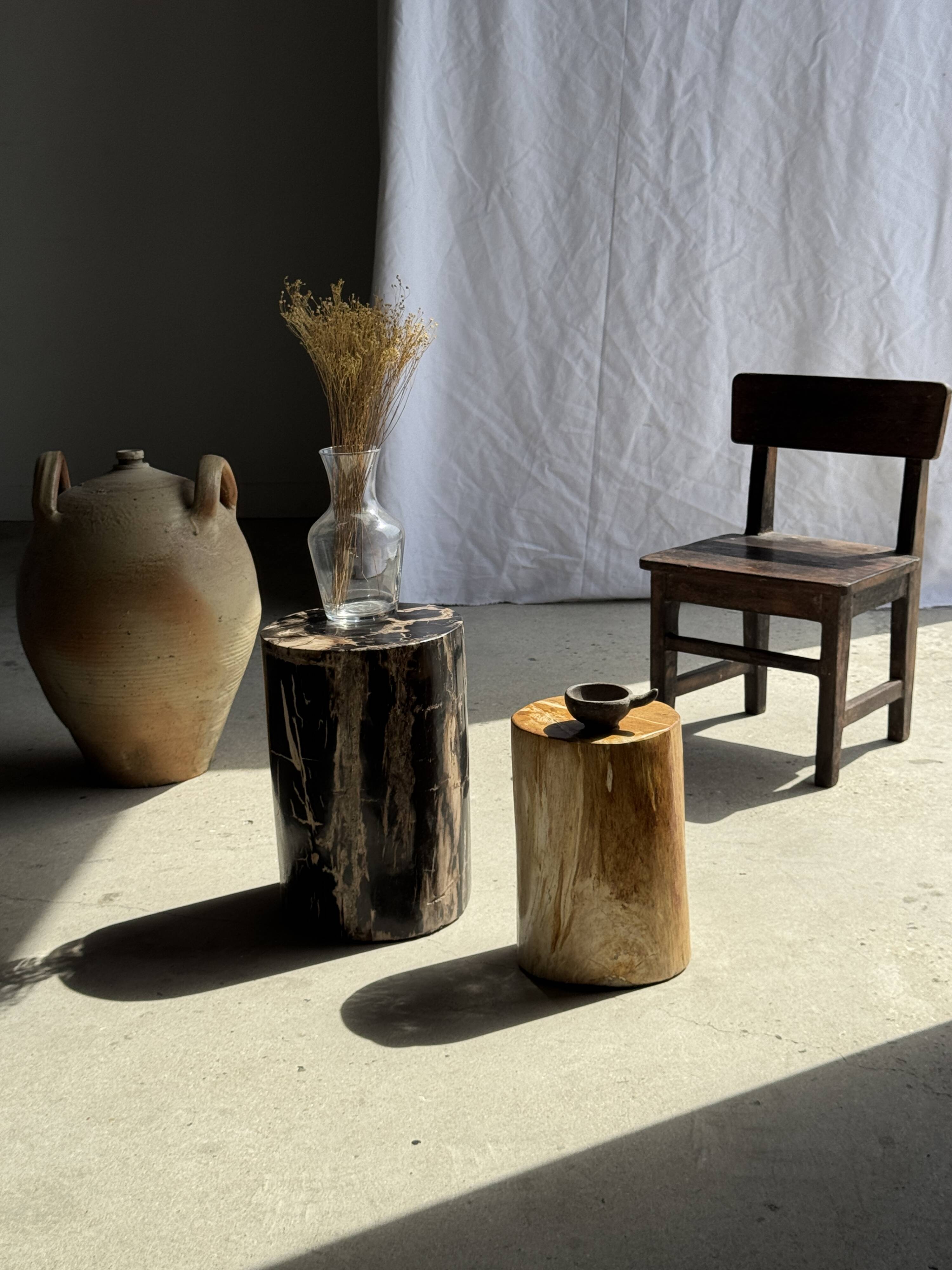 Black petrified wood side table with beige stripes and a semicircular shape.