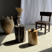 Black petrified wood side table with beige stripes and a semicircular shape.
