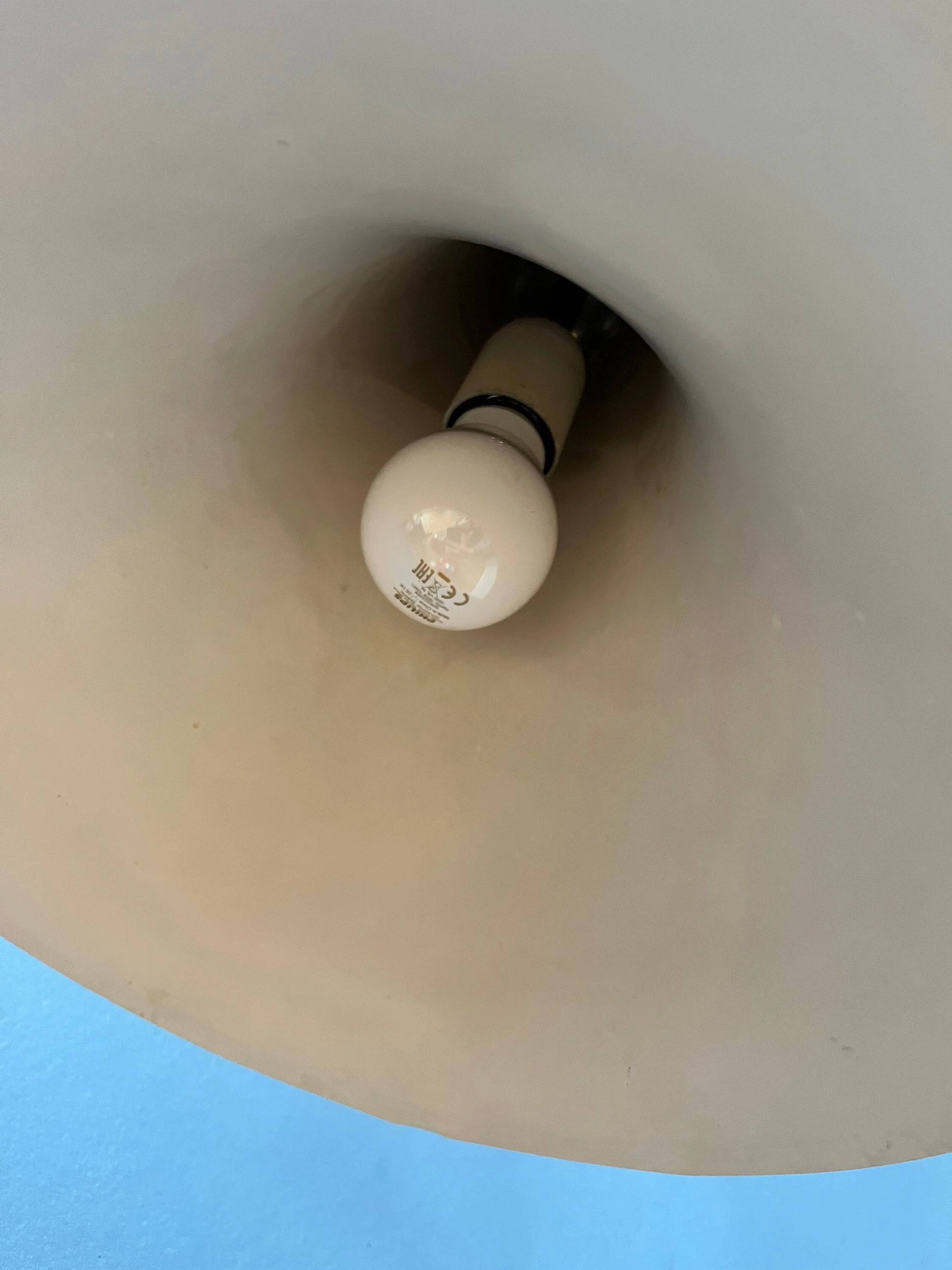 Small vintage beige pendant light in the shape of a witch's hat.