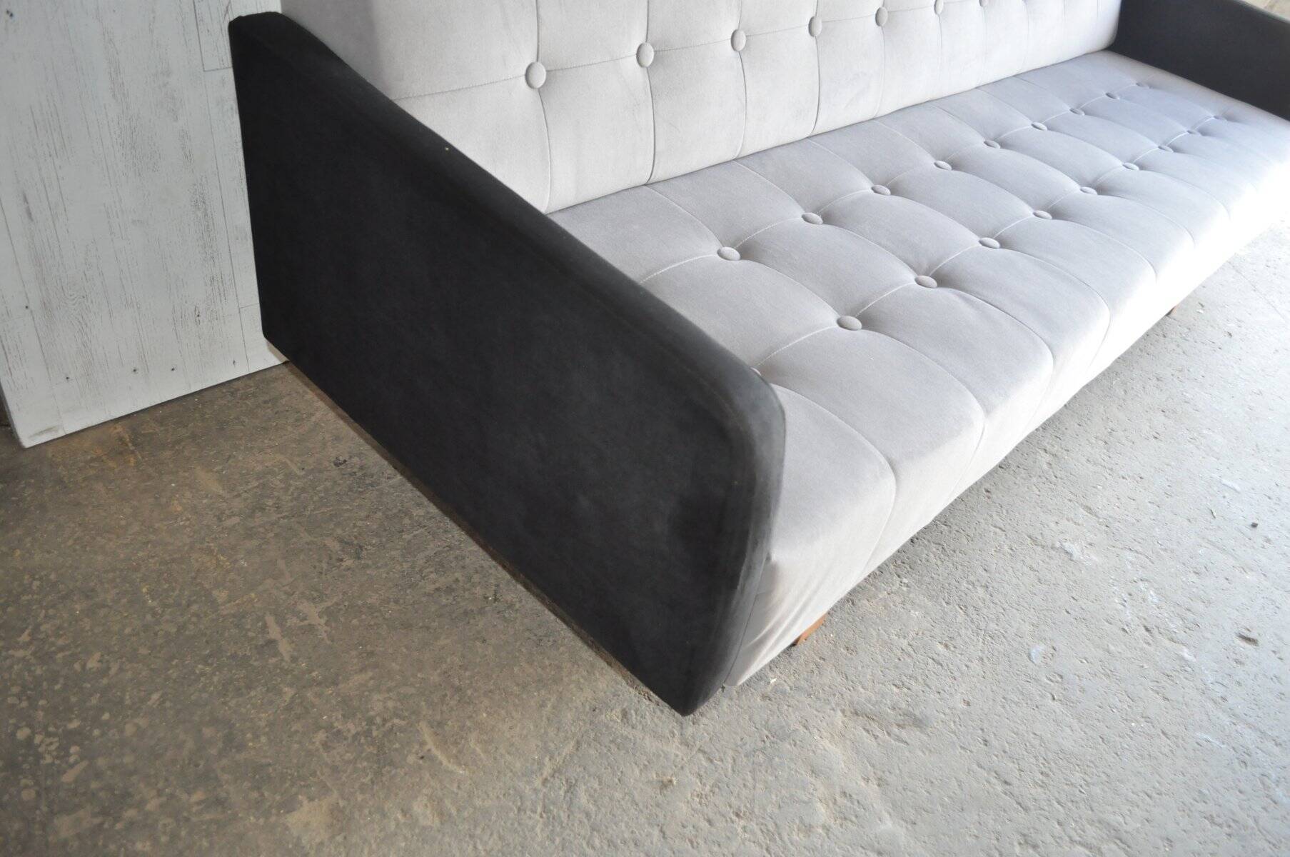 Mid-Century 1960s canapé in grey fabric with black armrests, natural wood base.