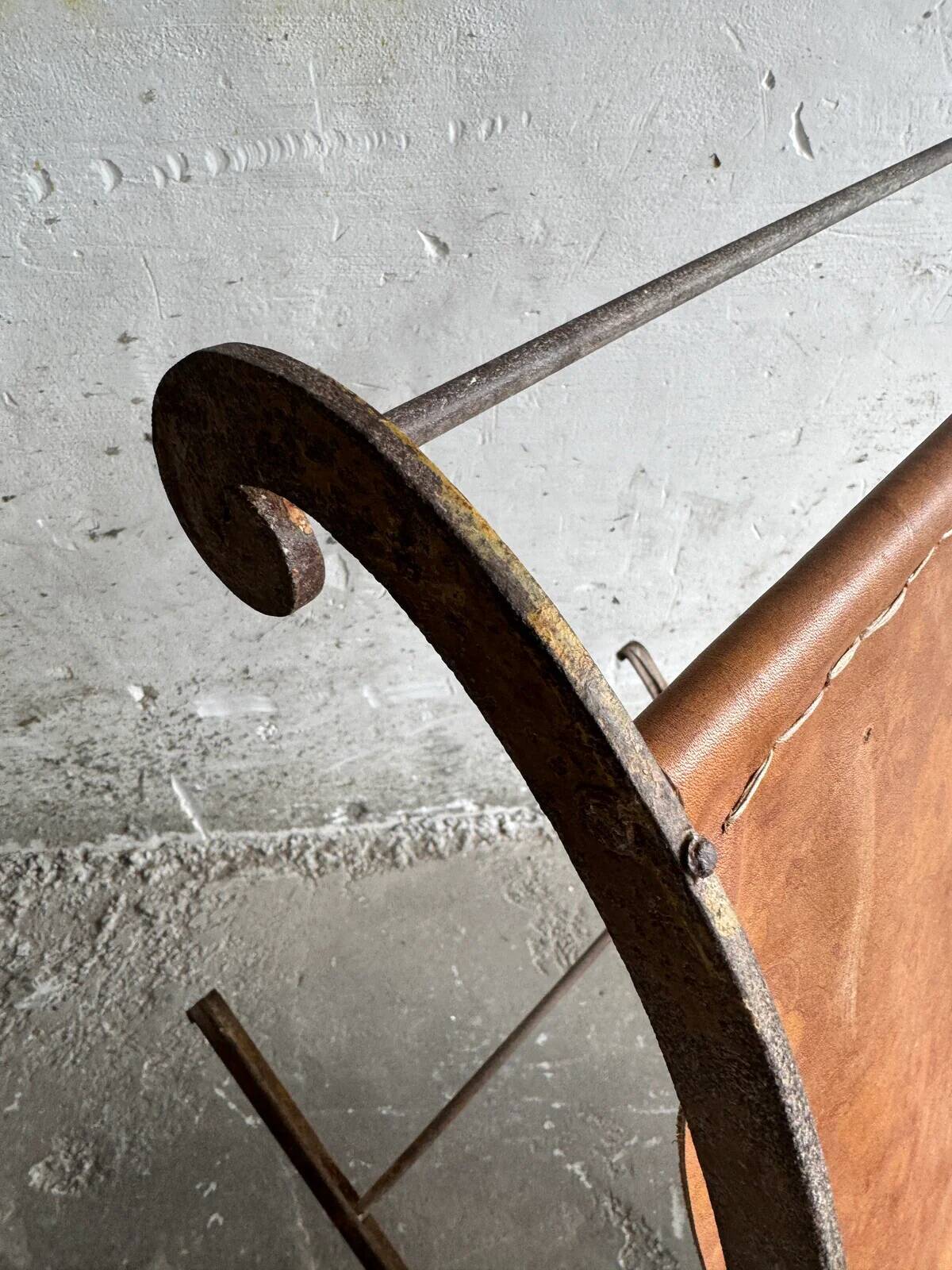 19th-century dark brown wrought-metal rocking chair with cognac leather sling seat, vintage