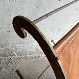 19th-century dark brown wrought-metal rocking chair with cognac leather sling seat, vintage