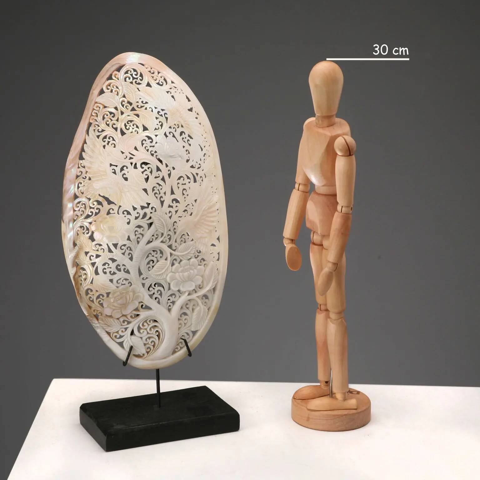 Perforated shell hand-decorated on a wooden base