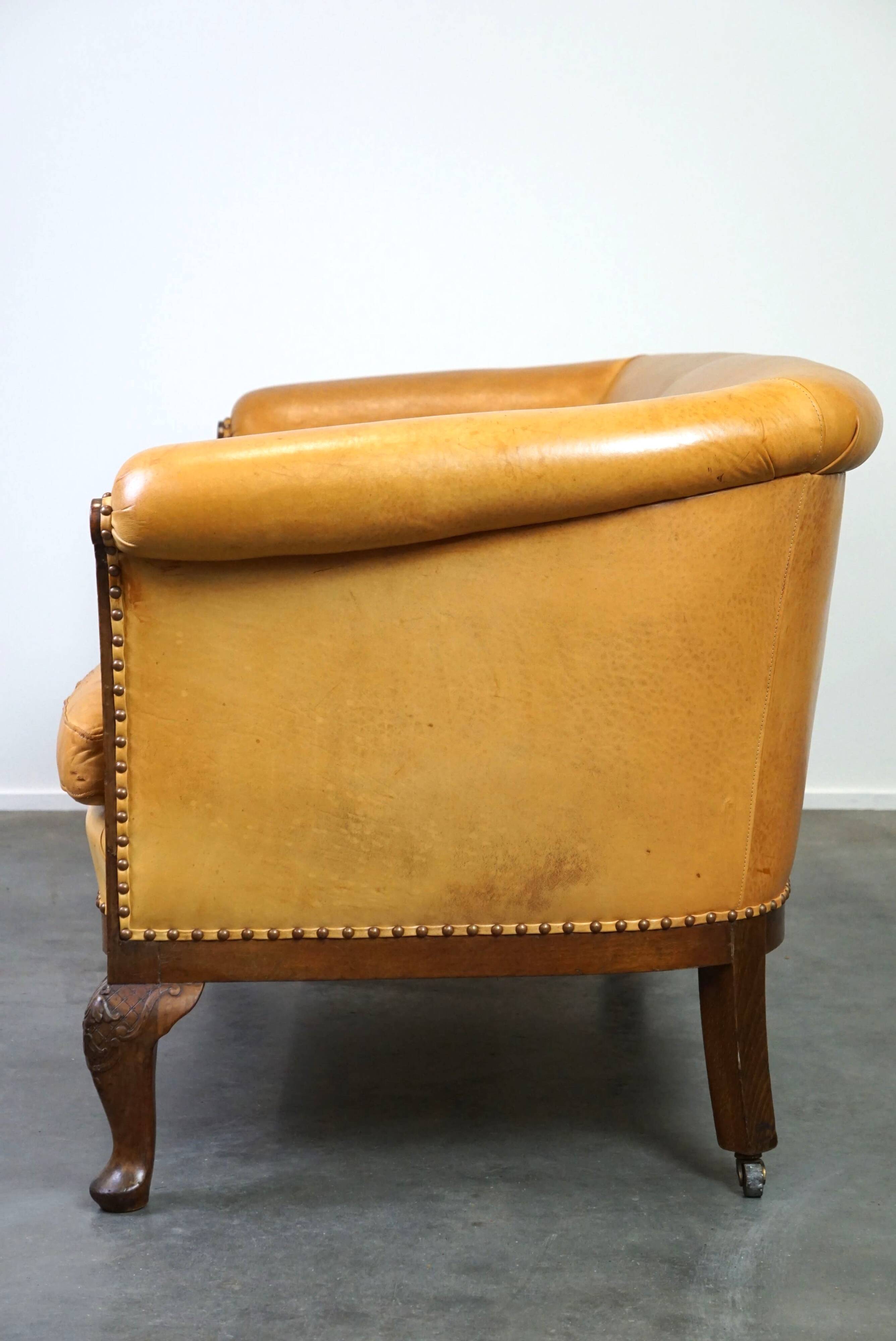 Unique old set of 2 club armchairs and a couch in cognac-colored leather with wheels