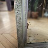 Old mirror with light green contours with mauve shades