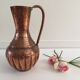 Pitcher-shaped vase in hammered copper