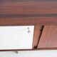 Wooden sideboard with sliding door and white drawers, around 1960.