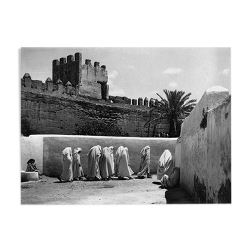 Women in white under the ramparts of Fez around 1930.