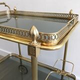 Neoclassical style rolling table in brass with blue glass tops