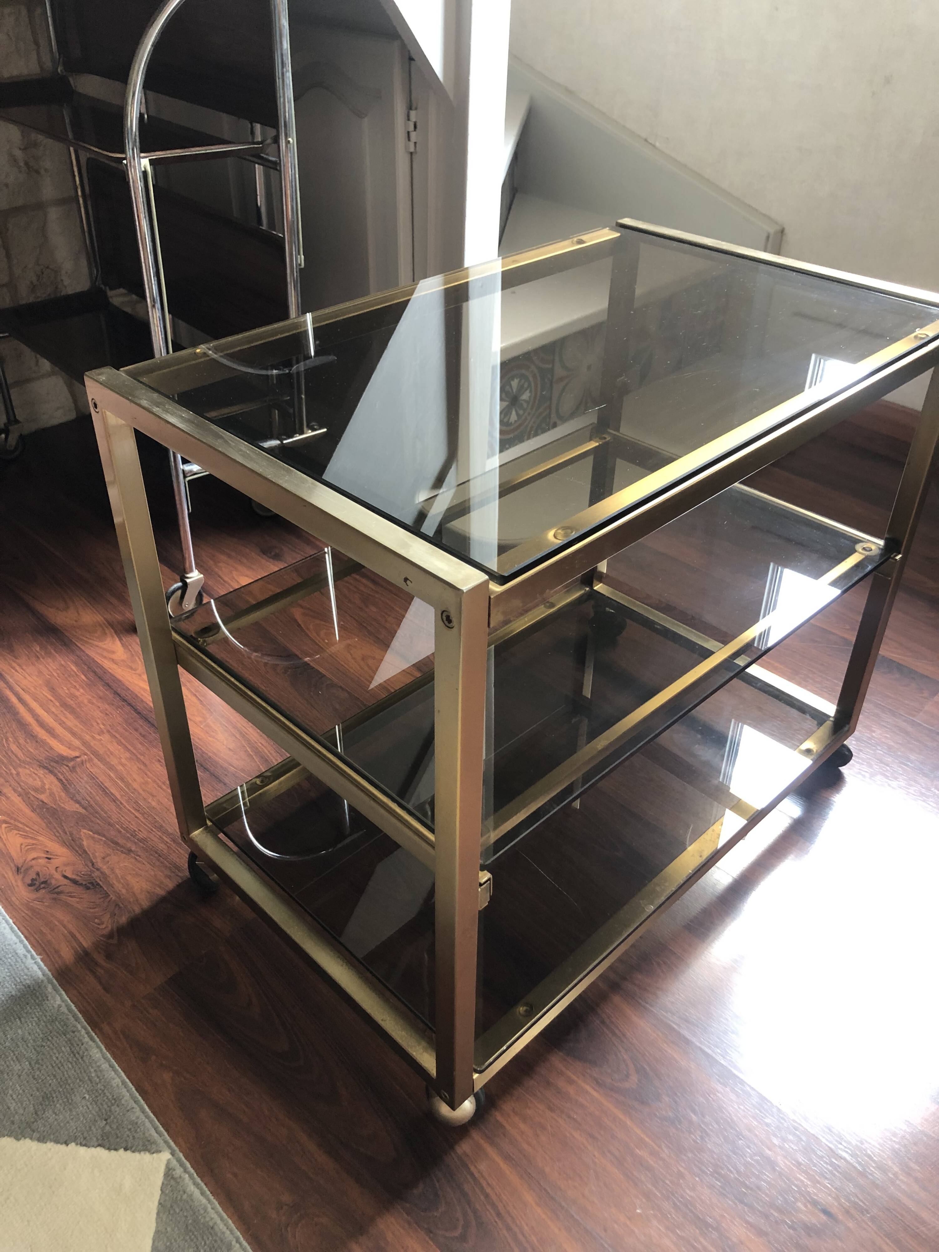 Vintage brass serving trolley with smoked glass trays.