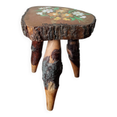 Tripod stool plant holder with hand-painted floral design.