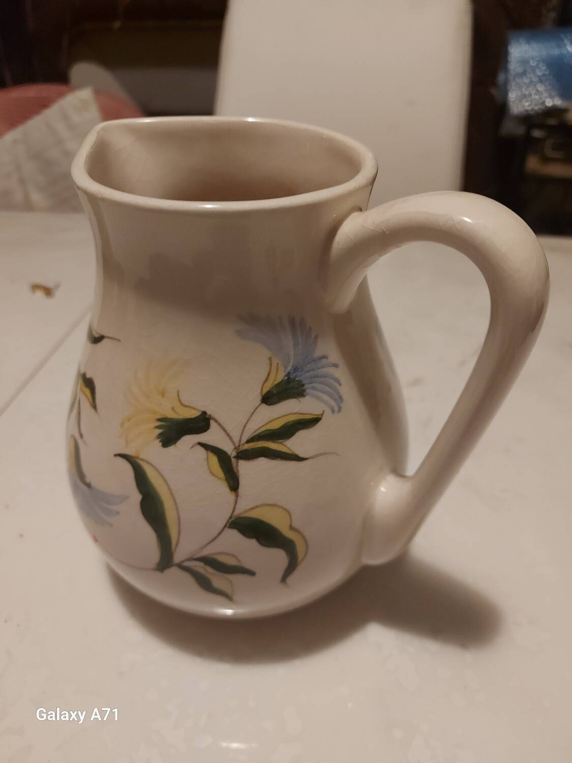 Earthenware pitcher with floral motifs in the Moustiers style, signed.