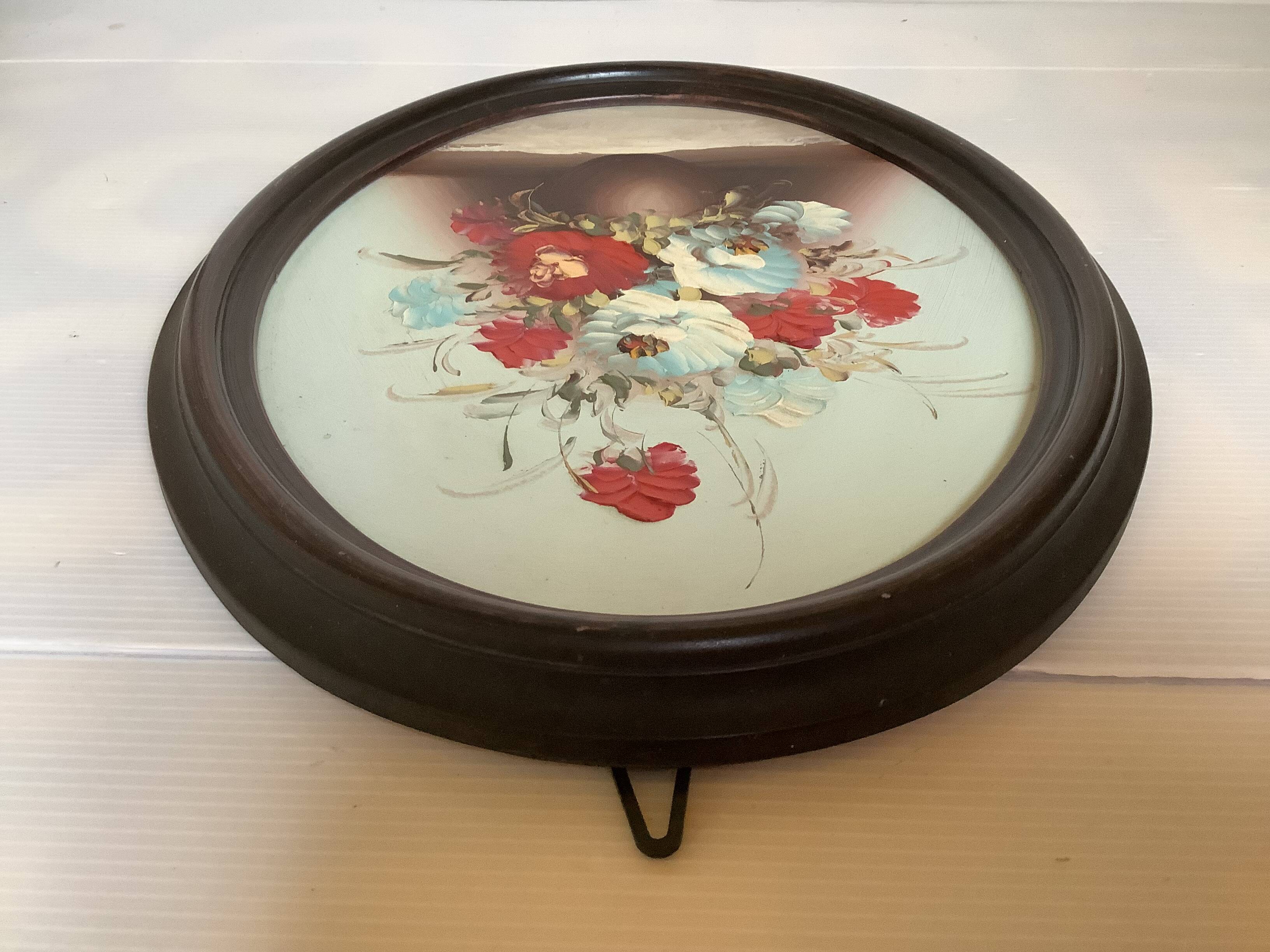 Oval painting of a bouquet of flowers, oil on panel.