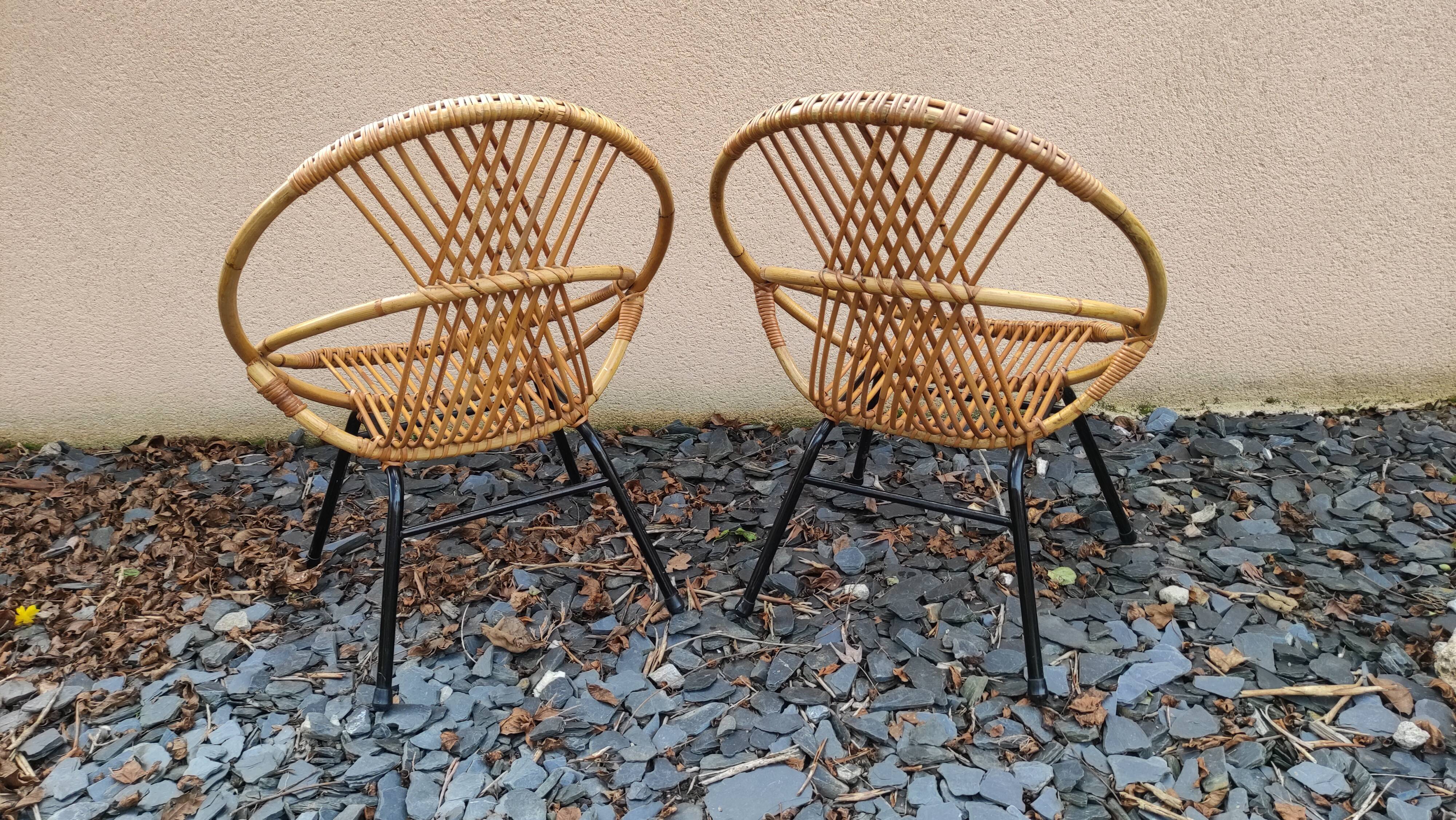 Paire de fauteuils coquilles ou corbeille en rotin tressé, pieds en métal