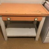 Vintage wooden kitchen table in orange and white with a drawer and low shelf.