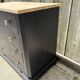Antique commode with a matte black finish.