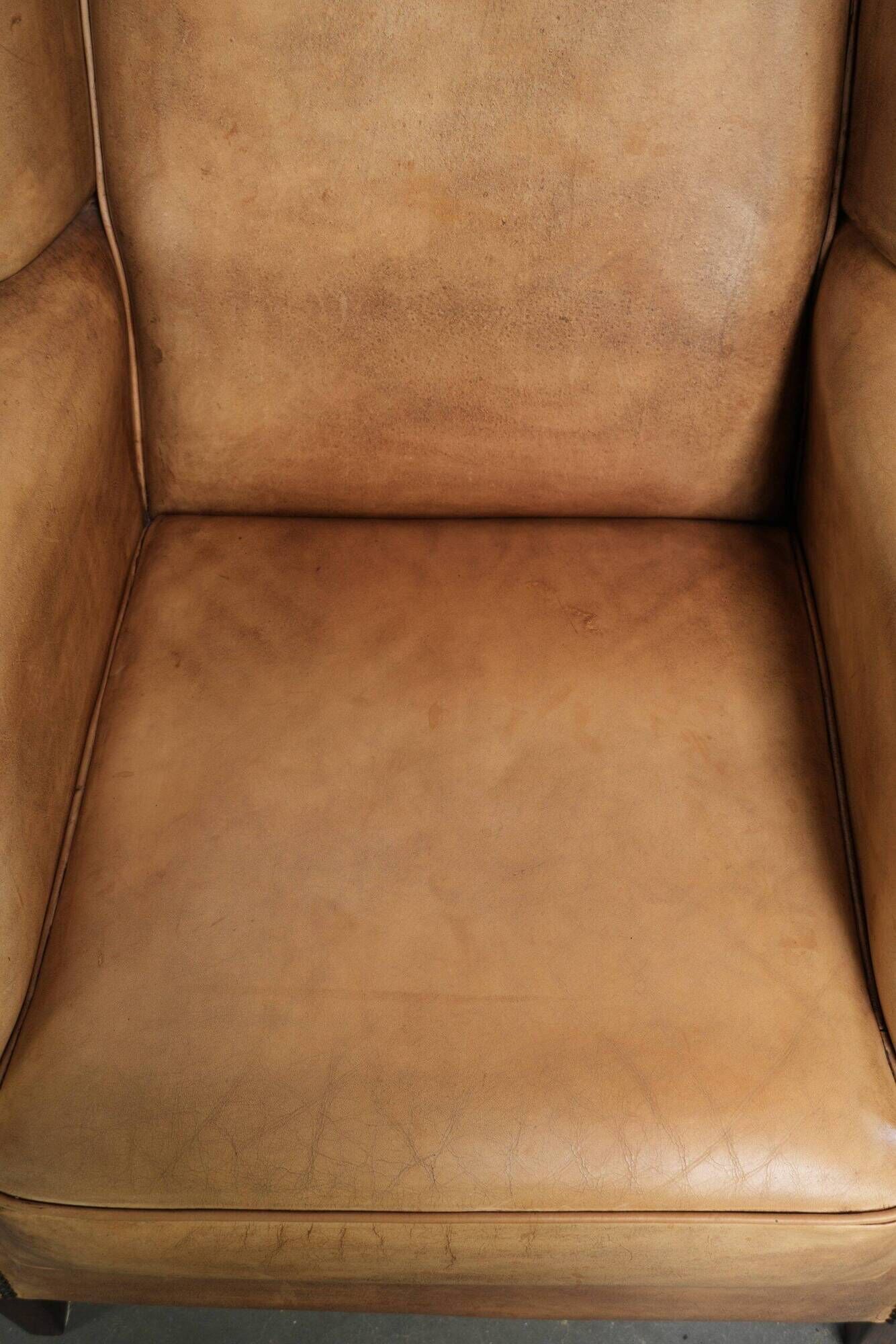 Set of two light cowhide wingback armchairs with a timeless English look