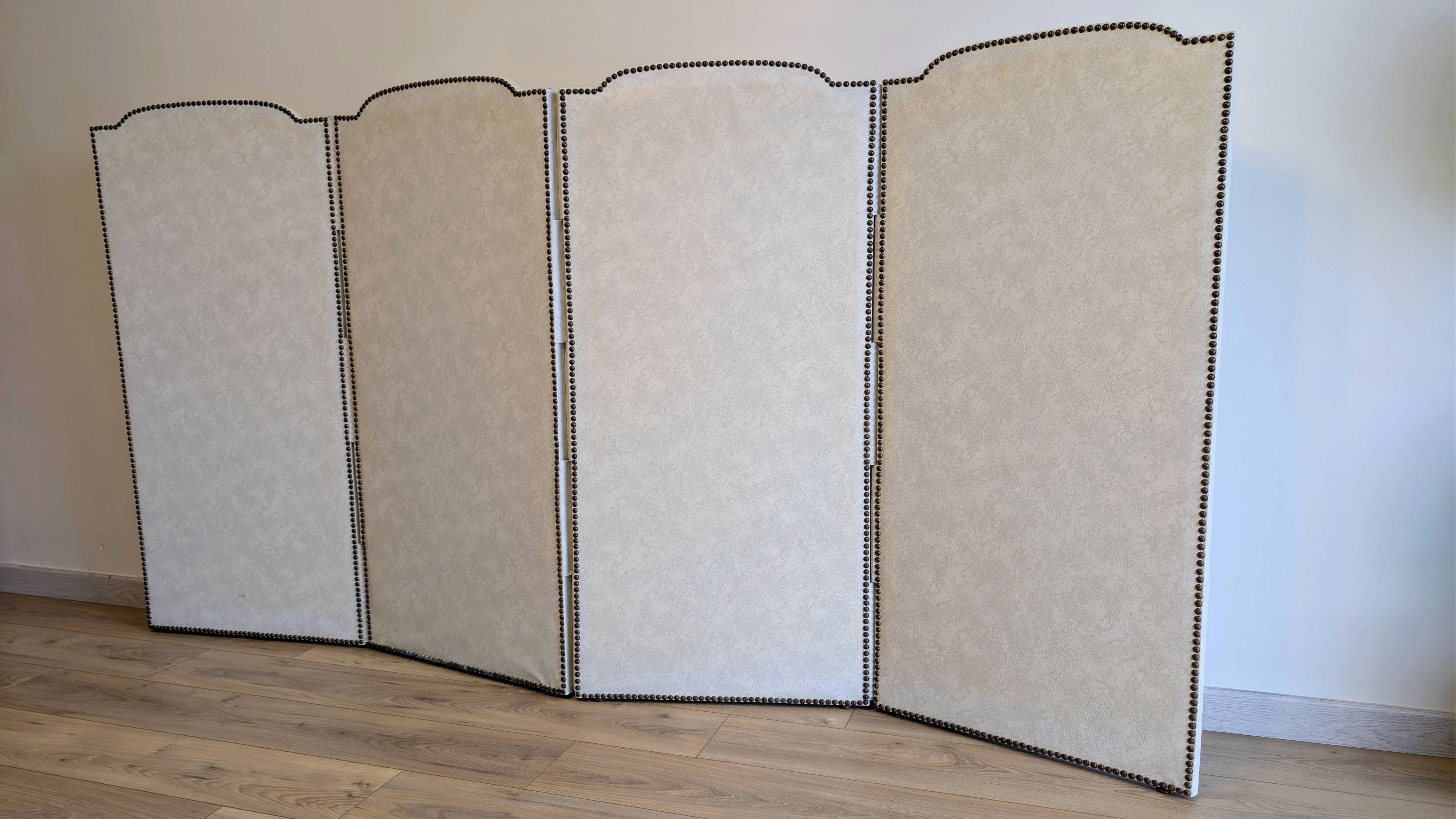Vintage white faux leather screen with four studded panels, elegant decor.