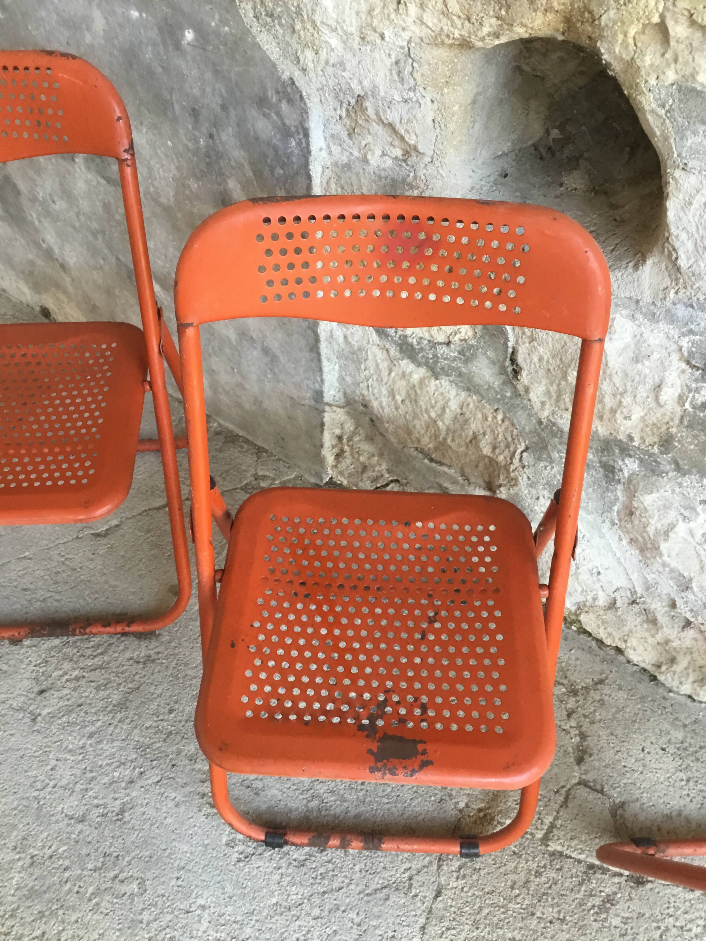 Trio of orange metal folding chairs - vintage
