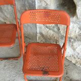 Trio of orange metal folding chairs - vintage