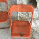 Trio of orange metal folding chairs - vintage