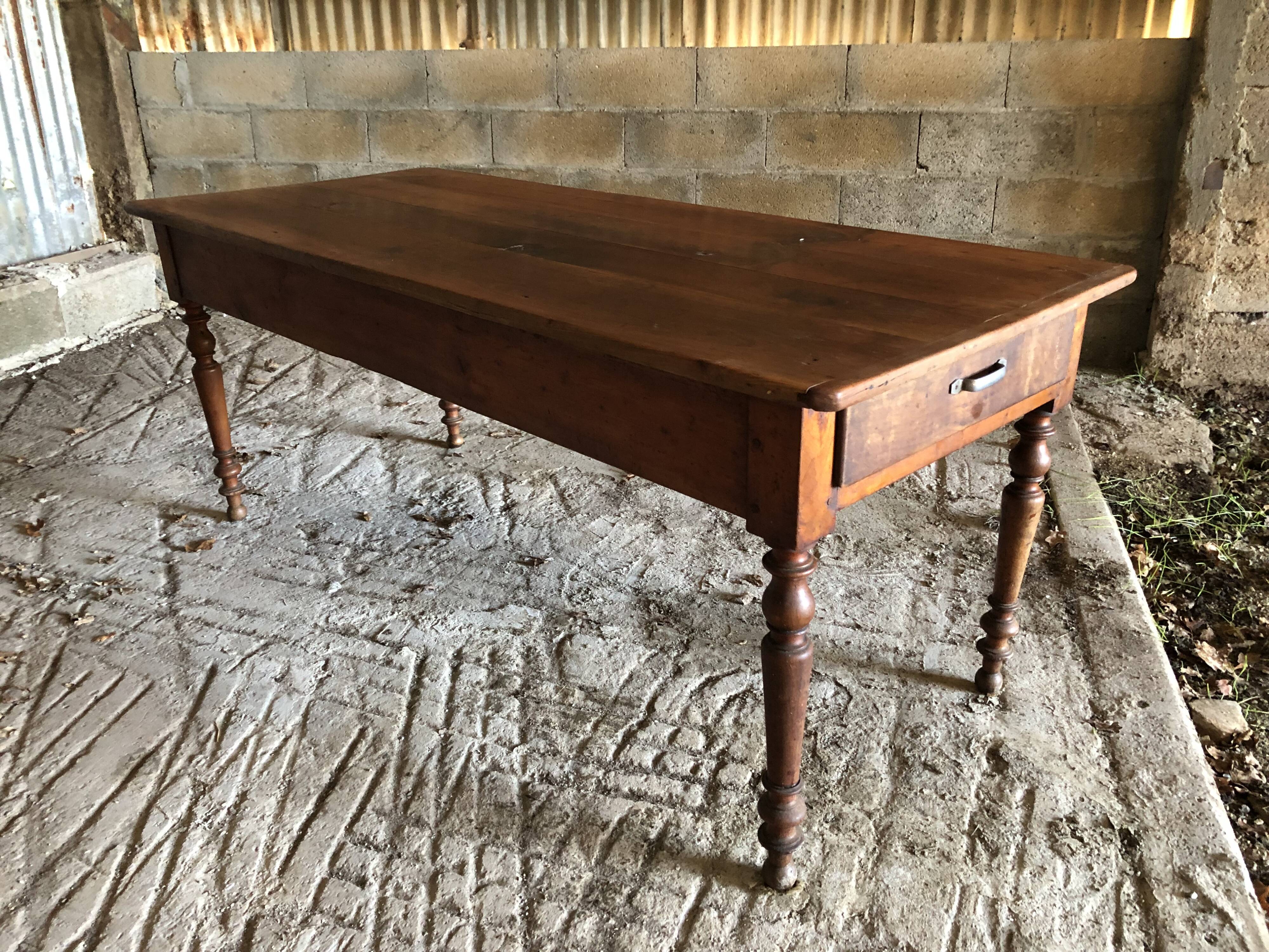 Antique Louis Philippe style farm table in solid cherry wood with turned base.