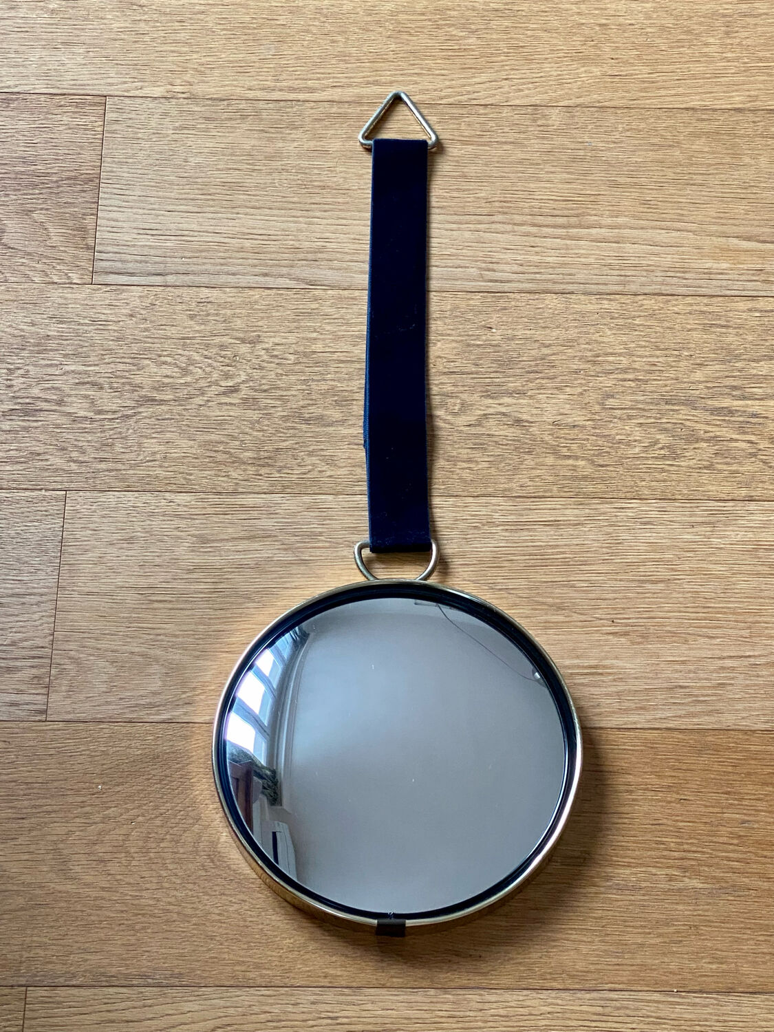 Vintage witch's eye curved mirror hangs velvet ribbon