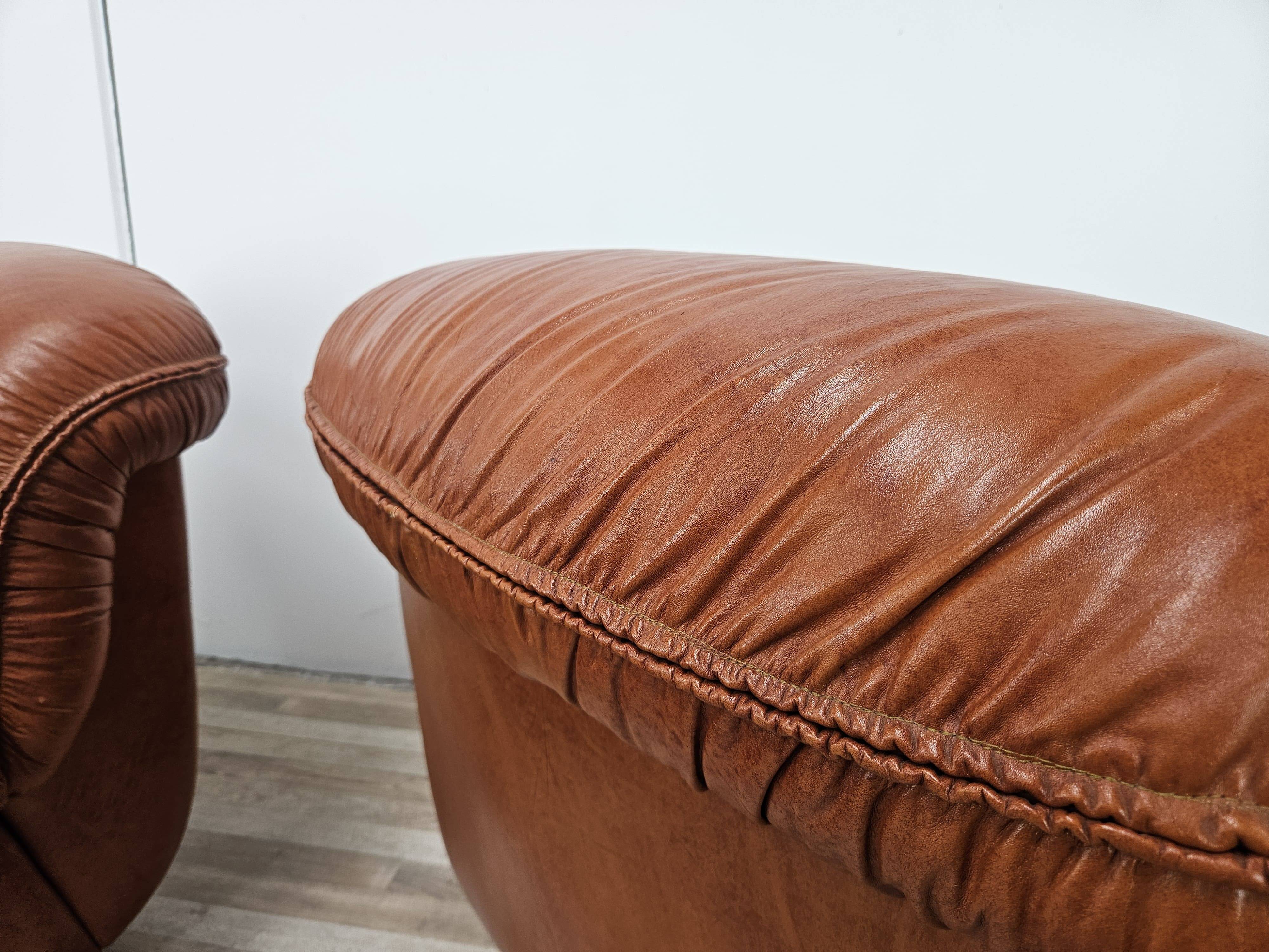 2 fauteuils en cuir cognac, années 1970