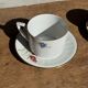 Pair of white porcelain cups from ADP France with a floral pattern and their s