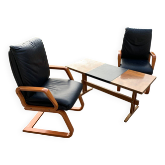 Mid-century ensemble from the 1960s: 2 black fabric armchairs and a wooden and black coffee table.