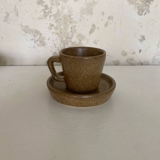 Set of stoneware coffee cups with saucers.