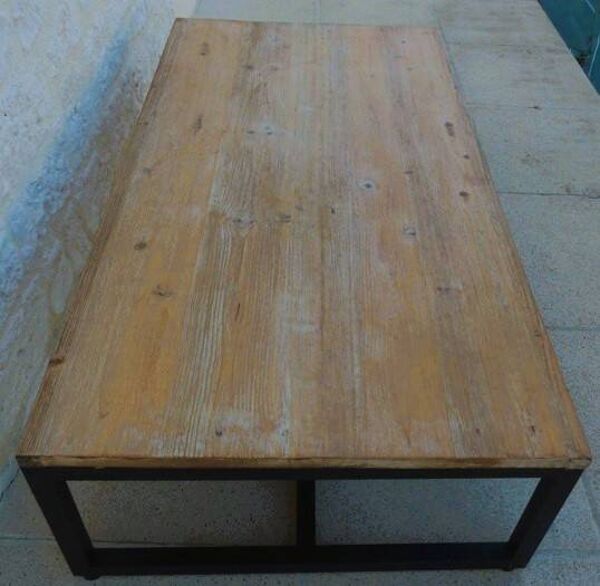 Table basse de style industrielle à plateau de bois supporté par un piètement métallique-