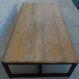 Table basse de style industrielle à plateau de bois supporté par un piètement métallique-
