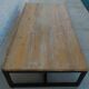 Industrial style coffee table with wooden top supported by a metal base -