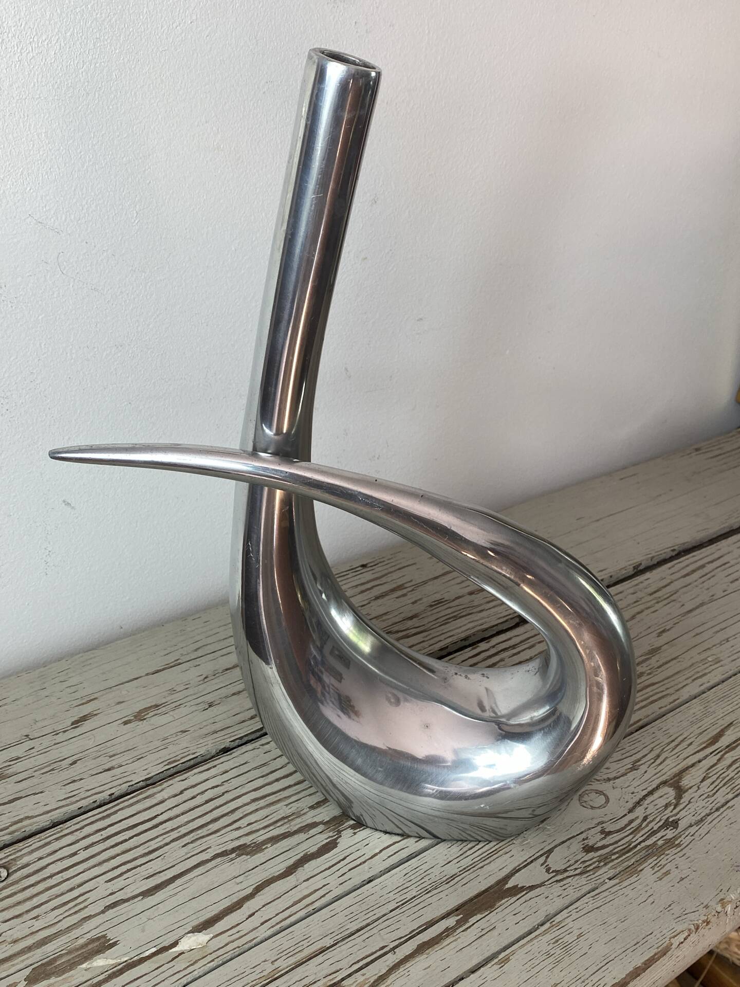 Sculptural vase design in polished aluminium.