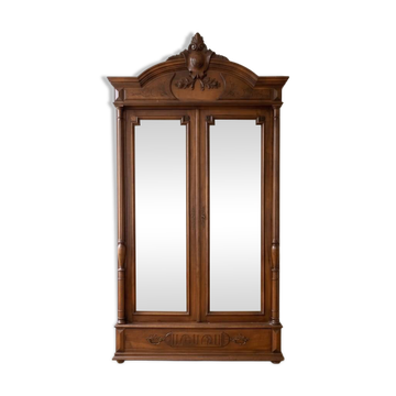 Antique walnut wardrobe with bevelled mirrors.