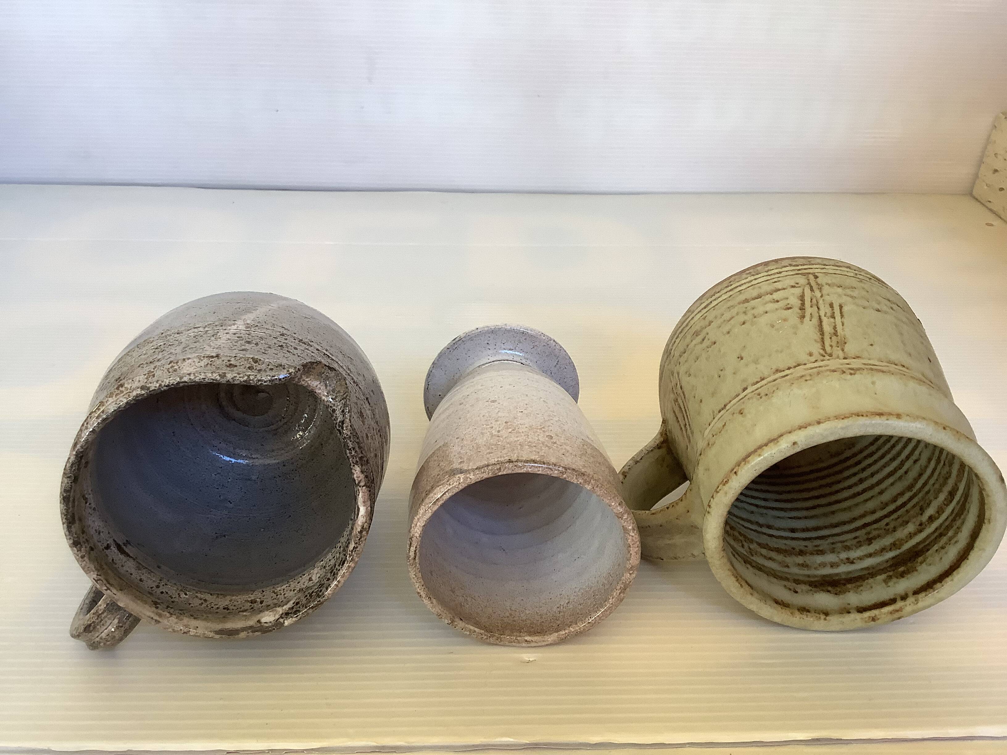 Seven beige and gray ceramic vases