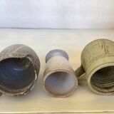 Seven beige and gray ceramic vases