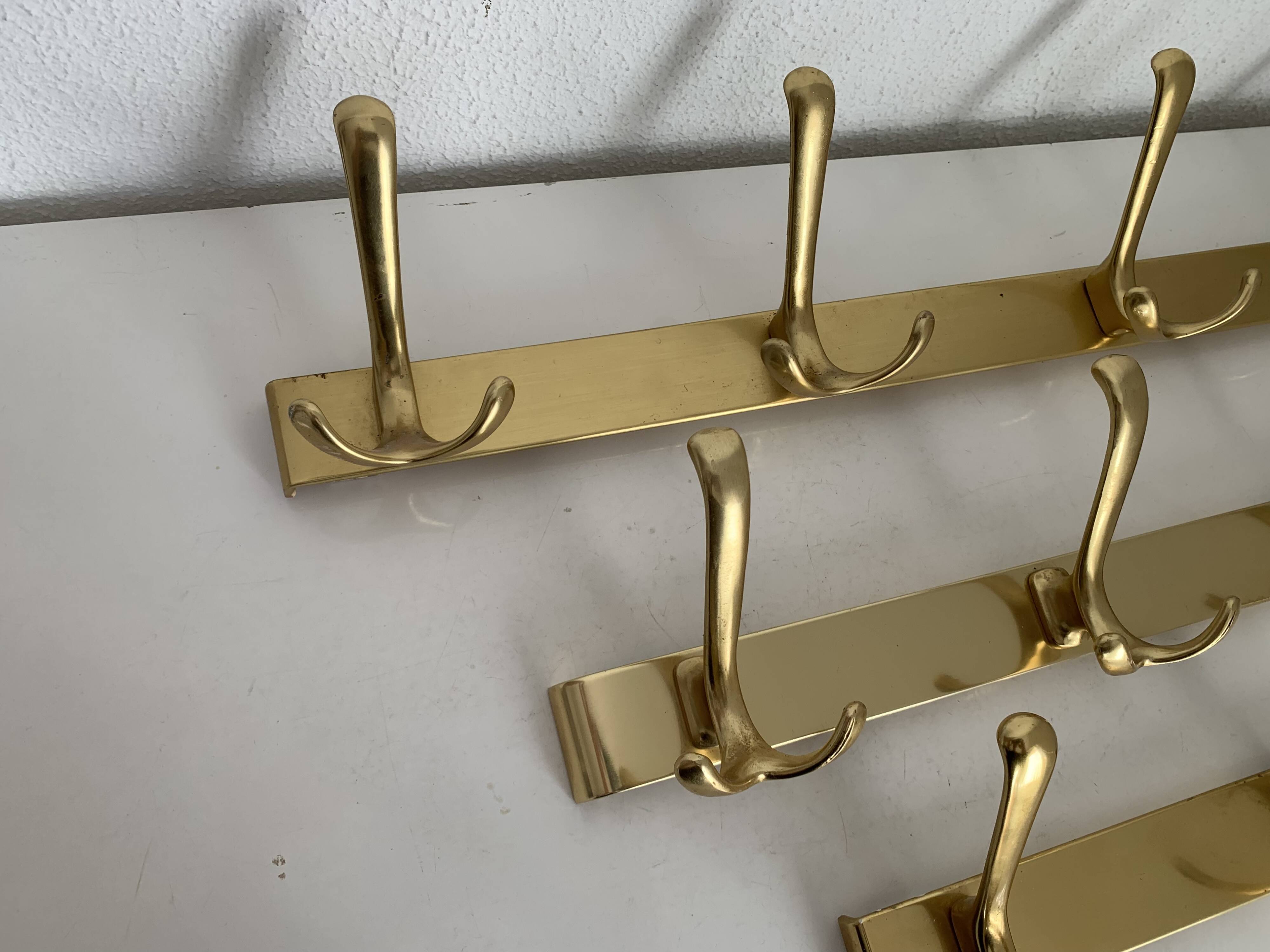 Three vintage 1960s gold coat racks with 4, 3 and 2 hooks
