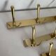 Three vintage 1960s gold coat racks with 4, 3 and 2 hooks