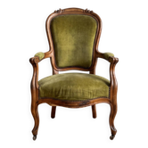 Antique armchair in olive green velvet and carved wood.