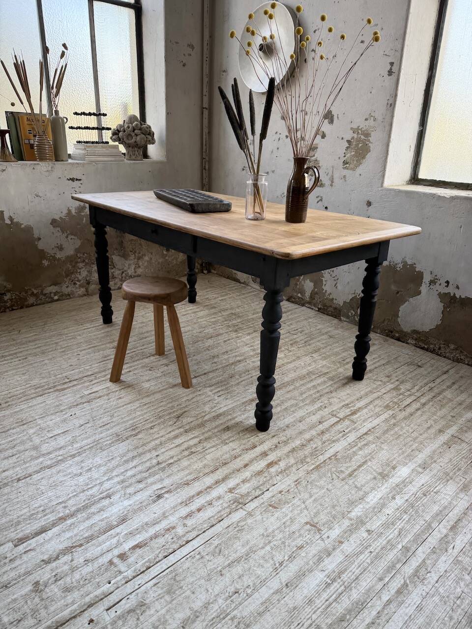 Oak farmhouse table with turned black legs.