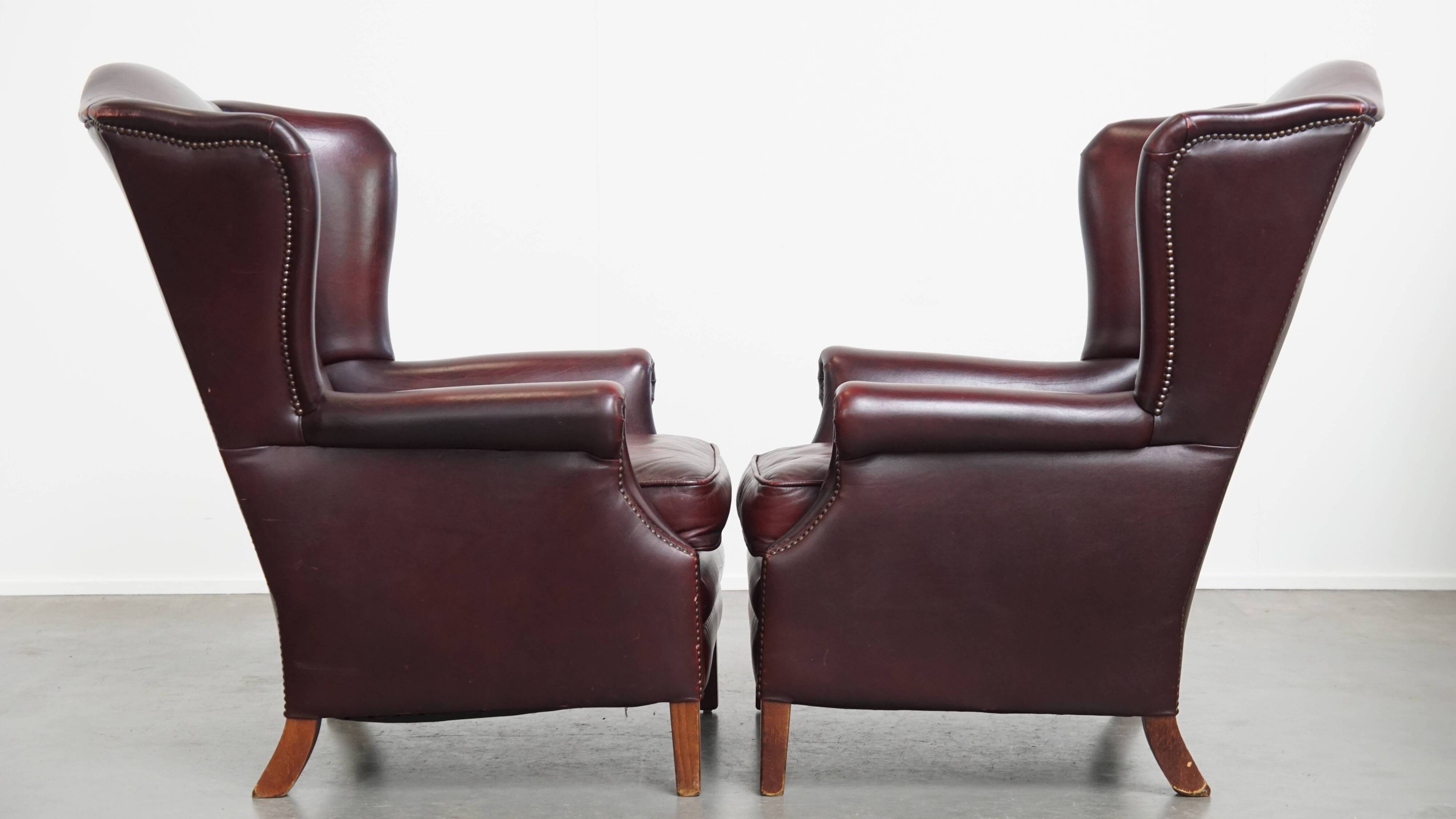 Ensemble de 2 fauteuils à oreilles en cuir de vachette + pouf de style anglais