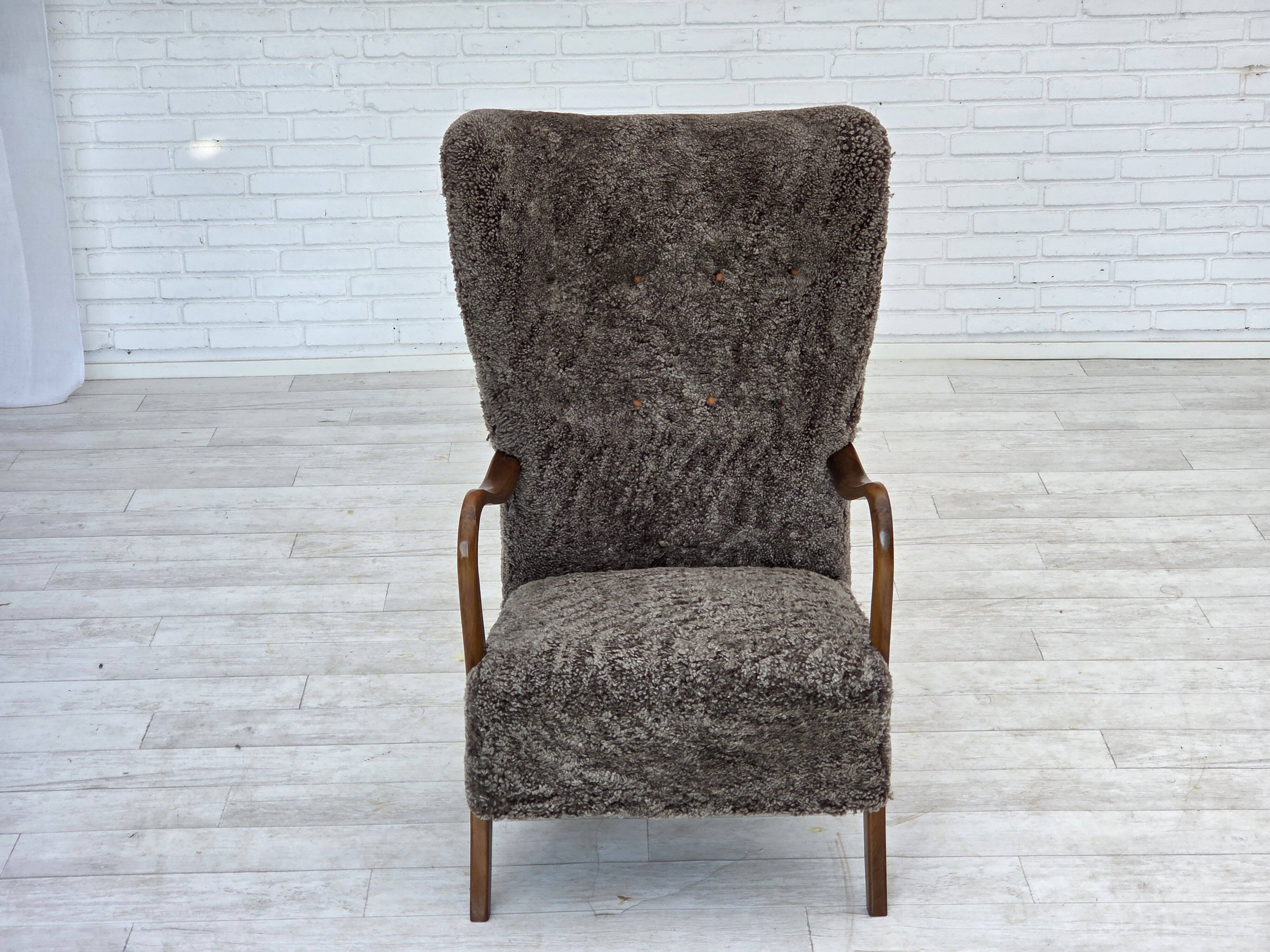 1960s, reupholstered Danish armchair, with stool, genuine sheepskin.